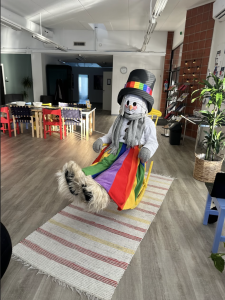 Arctic Pride maskotti keinumassa toimistolla keinutuolissa